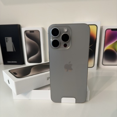 Smartphone Apple iPhone cinza com três câmaras na traseira em cima de caixas de iPhone