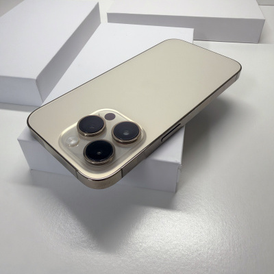 Smartphone dourado com câmaras traseiras grandes sobre caixas brancas