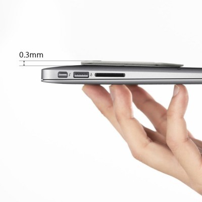 Computador portátil cinzento prateado segurado por uma mão, visto de lado com portas USB e leitor de cartões