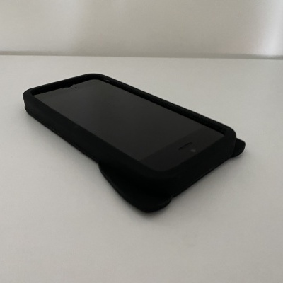 Smartphone com capa preta sobre superfície branca