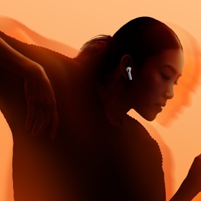 Mulher com auscultadores sem fios brancos contra fundo laranja com silhuetas duplas