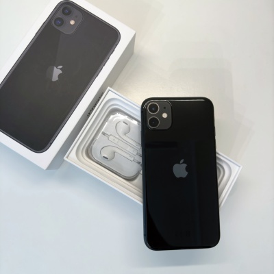 Smartphone preto Apple iPhone sobre caixa branca com auscultadores