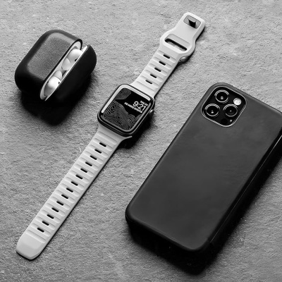 Relógio smartwatch branco, auriculares sem fios e telemóvel preto sobre superfície cinza