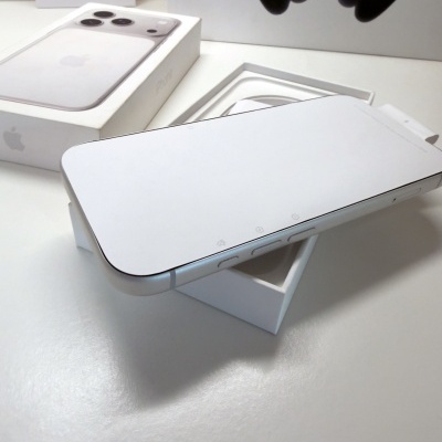 Smartphone Apple iPhone branco numa caixa aberta sobre mesa branca com embalagem ao fundo