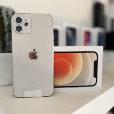 iPhone branco em suporte à frente da sua caixa com vaso de cacto ao fundo