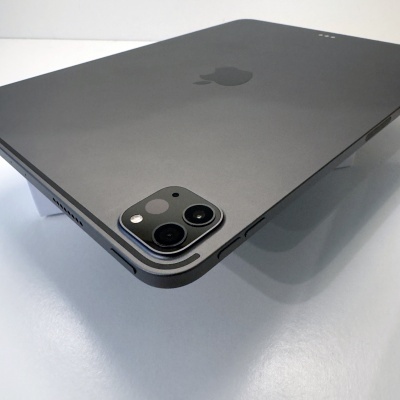 Tablet Apple iPad Pro cinzento com duas câmaras traseiras sobre mesa branca