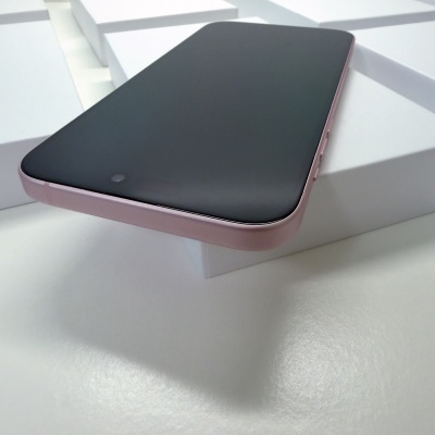 Smartphone com ecrã preto e bordas rosa sobre caixas brancas.