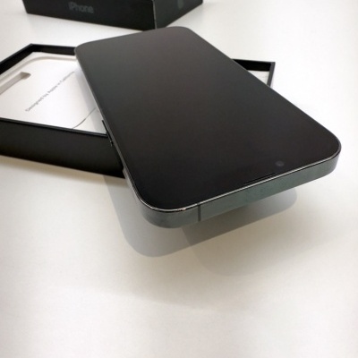 Smartphone preto sobre caixa preta identificada com iPhone