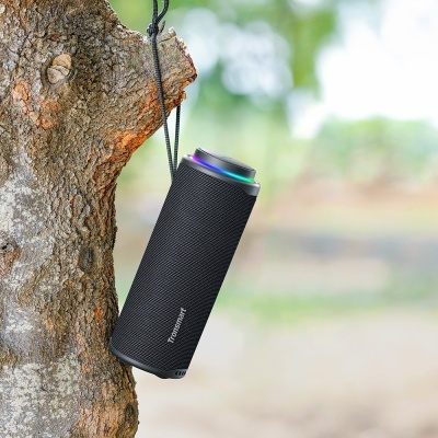 Coluna portátil preta com tecido e iluminação LED pendurada numa árvore