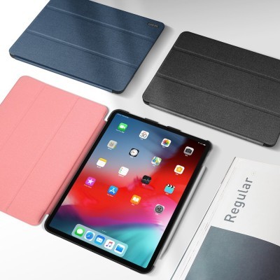 Tablet com capas coloridas em azul, preto e rosa e revista ao lado