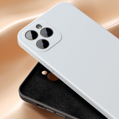 Dois smartphones com capas protetoras, um branco e um preto, sobre tecido bege.