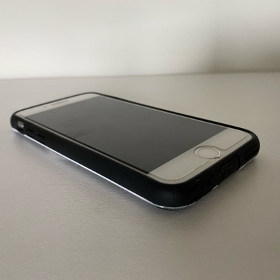 Smartphone com capa preta sobre superfície branca