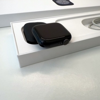 Smartwatch preto numa embalagem branca com caixa ao fundo