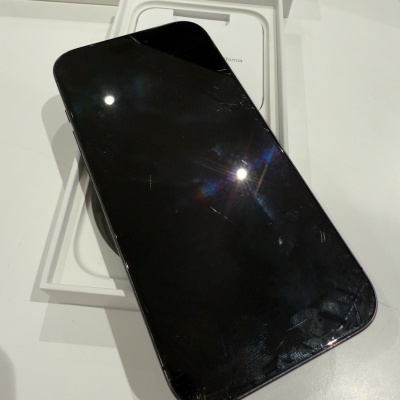 Smartphone preto com ecrã riscado numa caixa branca com 'iPhone' no fundo