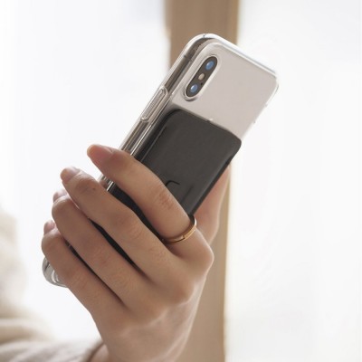 Smartphone com capa transparente e acessório preto a ser segurado por uma mão