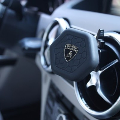 Suporte para smartphone preto com logótipo Lamborghini preso na saída de ar de carro