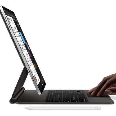 Tablet com capa-teclado preto e caneta digital branca com mão negra a digitar