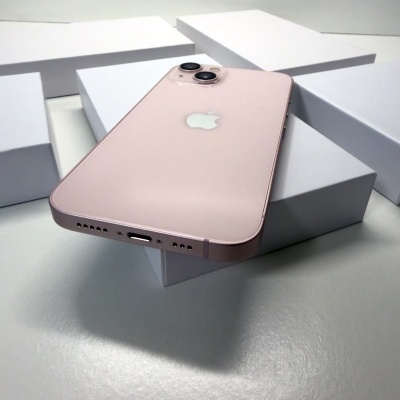 Smartphone Apple iPhone rosa com duas câmaras traseiras sobre caixas brancas.