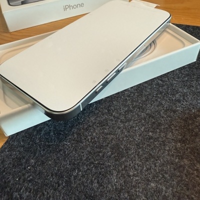 Smartphone branco com moldura metálica numa caixa branca com texto iPhone