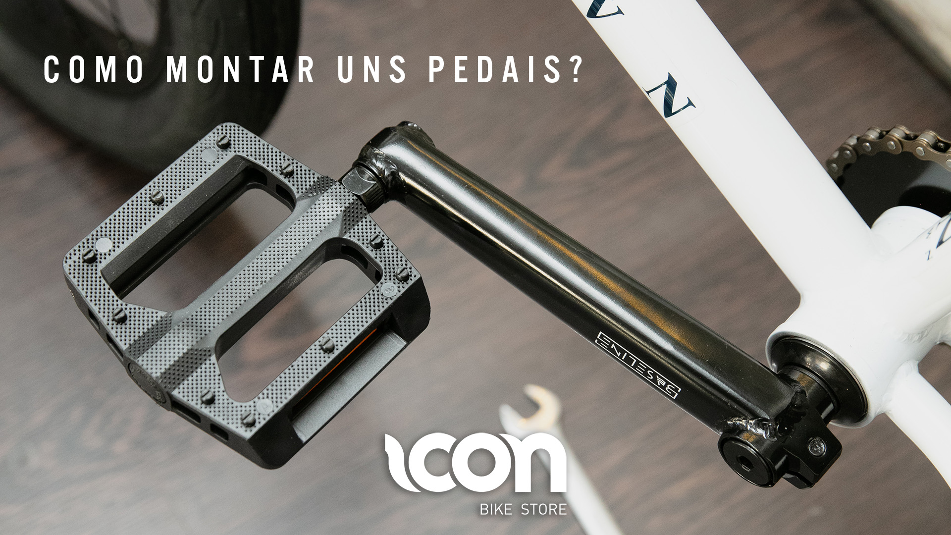 Pedal de bicicleta cinzento e pedaleira preta com texto e logo visíveis