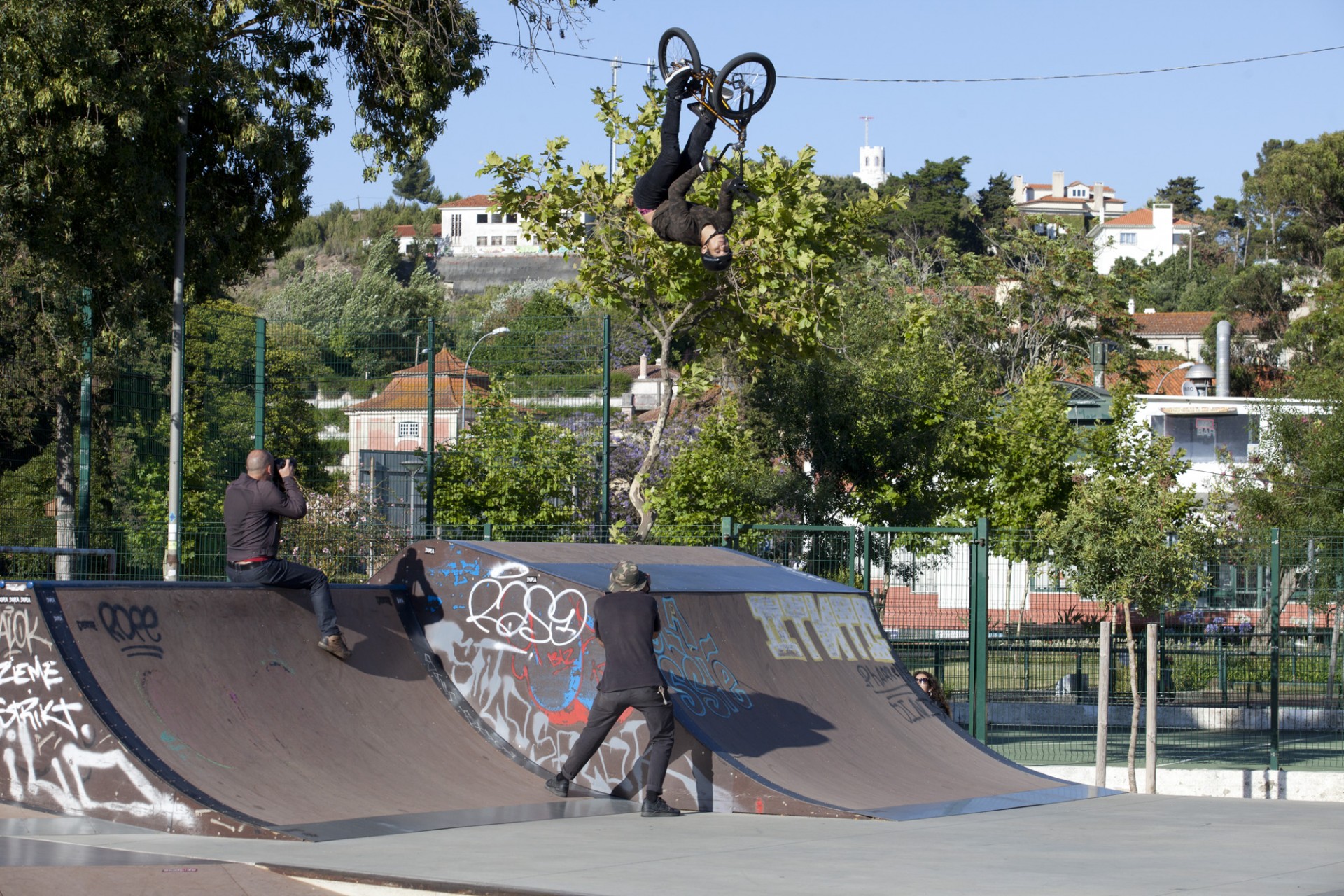 Skatepark ao ar livre com rampa, grafitis e pessoas skateando