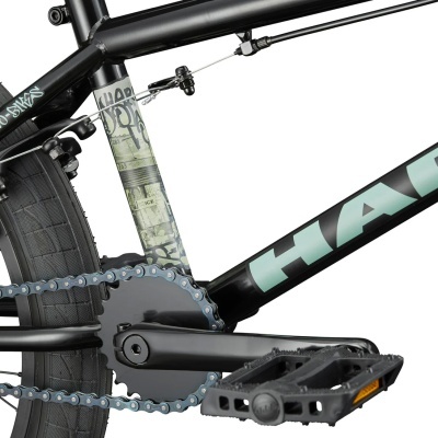 Parte traseira de bicicleta preta com detalhes gráficos e texto no quadro.