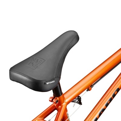 Selim preto para bicicleta com etiqueta HARO e quadro laranja.