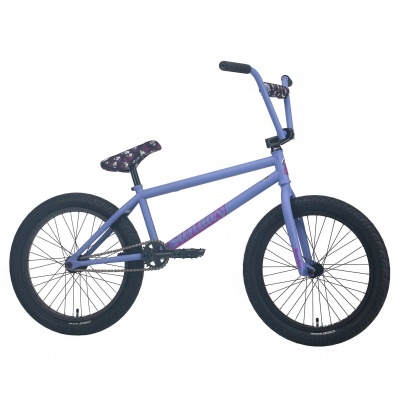 Bicicleta BMX lilás com pneus pretos e selim floral