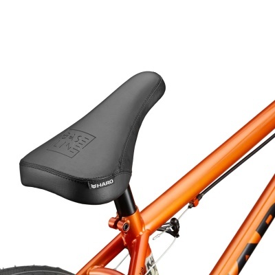 Selim de bicicleta preto com etiqueta HARO montado em quadro laranja