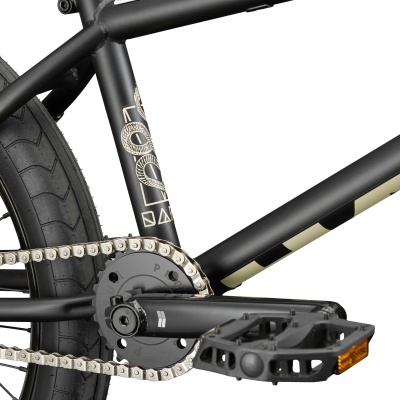 Detalhe do quadro preto fosco de uma bicicleta com corrente e pedal