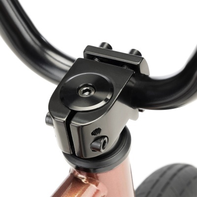 Suporte de guiador metálico preto numa bicicleta castanho acobreado com pneus negros