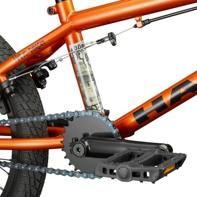 Bicicleta BMX laranja metálico com pneus pretos e texto HARO BIKES.