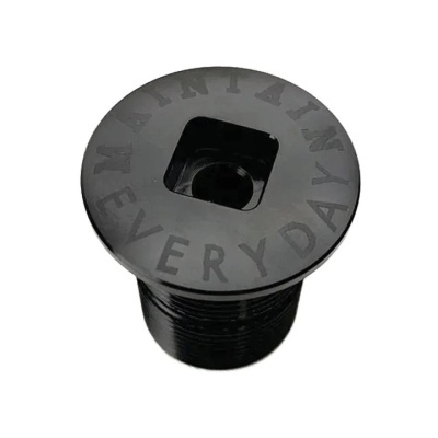 Peça metálica preta cilíndrica com topo circular gravado com texto e encaixe quadrado