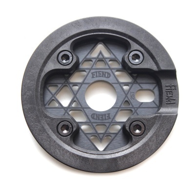 Peça redonda preta com padrão em estrela e textos SIENA, TREND e FREW