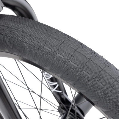 Pneu de bicicleta preto com padrão e sulcos em relevo sobre roda preta