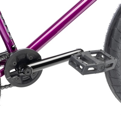 Pedaleira preta com pedal e quadro roxo metálico de bicicleta