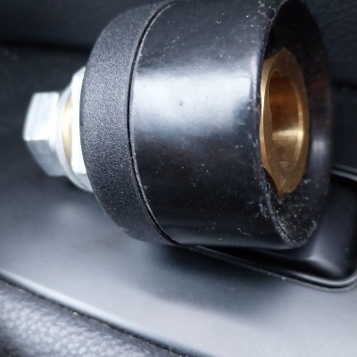 Peça metálica preta com interior dourado numa superfície de couro preto