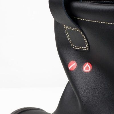 Bota de couro preto com costuras bege e ícones vermelhos de isqueiro e chama.