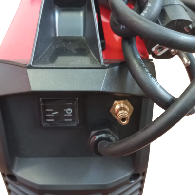 Máquina vermelha e preta com cabos e interruptor