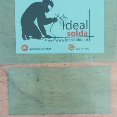 Placas translúcidas verdes com adesivo de empresa de soldadura em superfície de madeira