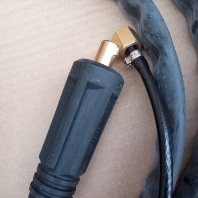 Mangueiras pretas de borracha com conetores metálicos dourados sobre papelão