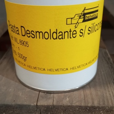 Frasco branco com rótulo amarelo de pasta desmoldante Helvetica sobre madeira