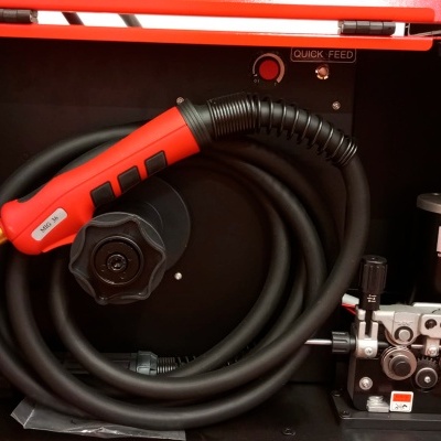 Equipamento de soldadura com pega vermelha e preta e mangueira preta