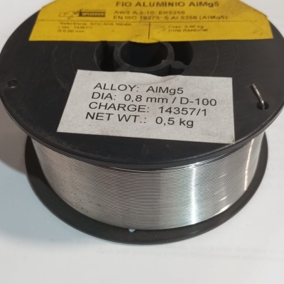 Carretel preto com fio de alumínio prateado e etiquetas amarelas e brancas com texto técnico