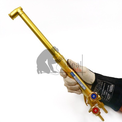 Maçarico dourado para soldadura com válvulas coloridas e mão enluvada a segurar