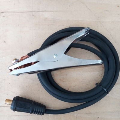 Cabo de soldadura com garra metálica e cabo preto sobre mesa de madeira