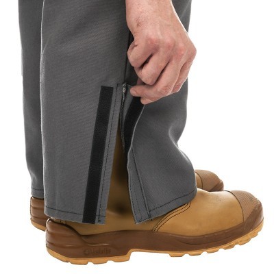 Calças cinzentas com fecho de correr e velcro na bainha com botas castanho claro