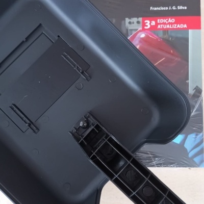 Livro sobre soldadura ao lado de bandeja plástica preta com alça.