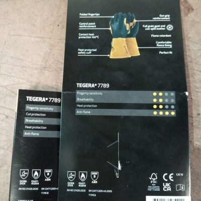 Embalagem preta e amarela de luvas Tegera 7789 tamanho X-Large com descrição das características técnicas e certificações.