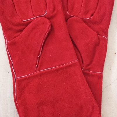 Par de luvas vermelhas de camurça com costuras brancas sobre superfície clara